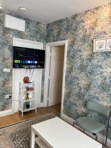a living room with floral wallpaper on the walls at 1 bed cozy apartment central London in London
