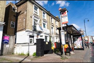 a bus stop on a street in front of a building at 1 bed cozy apartment central London in London