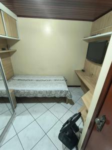 a small room with a bed and a tv at Casa Da Praça Independência in Arraial do Cabo