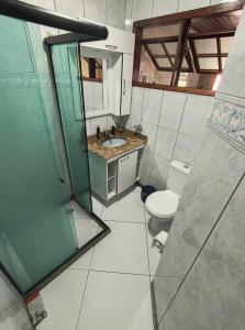 a bathroom with a toilet and a sink and a shower at Casa Da Praça Independência in Arraial do Cabo