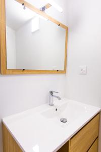 a bathroom with a sink and a mirror at Appartement Jelyad Terres Fortes 3 à 10 minutes de Disney in Chanteloup-en-Brie
