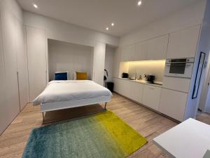 a bedroom with a large bed and a kitchen at Studio Fischer à la Pétrusse 301 in Luxembourg