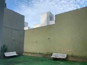 two benches sitting on the side of a building at Lo de Viki in Lomas de Zamora