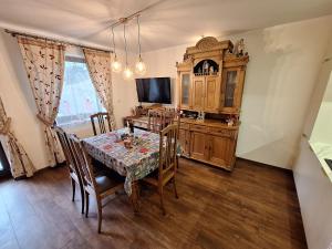 a dining room with a table and a tv at Chwile w Starym Sączu, sauna i beczka in Stary Sącz