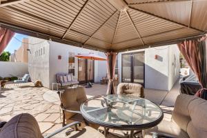 a patio with a glass table and chairs at Lavish Escape with Pool 1 Mi to Old Town La Quinta! in La Quinta