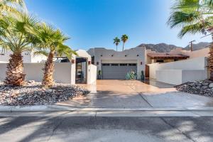 a house with palm trees in front of a driveway at Lavish Escape with Pool 1 Mi to Old Town La Quinta! in La Quinta
