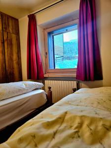 a bedroom with two beds and a window at Sunrise Livigno in Livigno