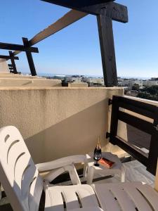 - kilka krzeseł i butelkę wina na balkonie, w obiekcie Résidence Port Nature Colline 3 - Appartement T2 4 pers - Port Nature Colline 3 MAE-2874 w Cap d'Agde