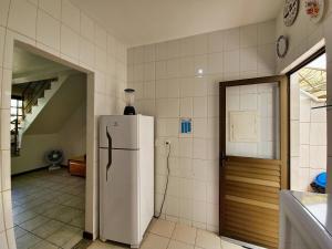 una cucina con frigorifero bianco in una camera di Casa de 2 Suítes com Internet Rápida e Comodidades a Belo Horizonte