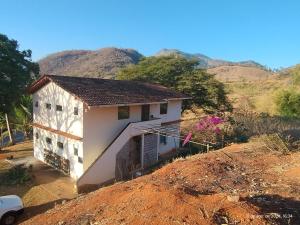 a house on a hill with mountains in the background at Kitnetes Mobiliadas in Estancia do Castello