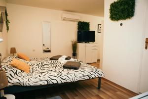 a zebra print bed in a room with a television at Laura in Slavonski Brod