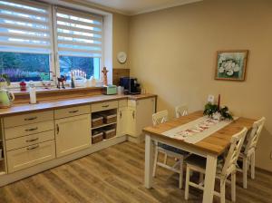 a kitchen with a wooden table and a dining room at Apartmán pro rodinu, kamarády in Bohosudov