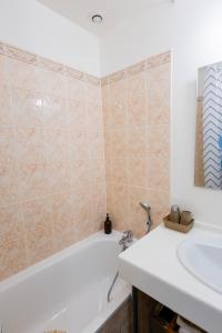 a bathroom with a bath tub and a sink at Appartement Jelyad Angelus proche Disney in Chanteloup-en-Brie