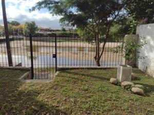 a fence in front of a body of water at CASA CENTRICA con SALIDA al RIO in Mina Clavero