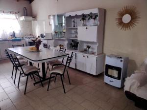 a kitchen with a table and chairs in a room at CASA CENTRICA con SALIDA al RIO in Mina Clavero
