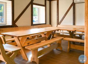 a large wooden table and benches in a room at Uždubysio baidarės Sodyba už Dubysos in Ariogala