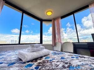 a bedroom with a large bed with large windows at Hawaii Movie Studio WaikikiSeaside4person in Honolulu +37 photos