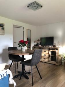 un salon avec une table, des chaises et une télévision dans l'établissement La Frégate, à Saint-Malo