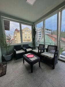 a living room with chairs and a table and windows at Hostel Herz in Banja Luka