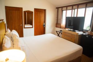 a bedroom with a bed and a flat screen tv at Estelar Santamar Hotel & Centro De Convenciones in Santa Marta