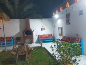 a living room with chairs and a fireplace at Dolphin guest house in Jazīrat al ‘Awwāmīyah