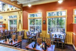 a restaurant with tables and chairs and windows at Denali Park Village in McKinley Park