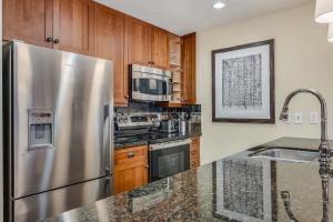 a kitchen with stainless steel appliances and wooden cabinets at Capitol Peak Lodge 3205 & 3207 by Snowmass Mountain Lodging in Snowmass Village