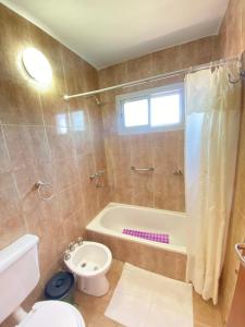 a bathroom with a tub and a toilet and a sink at Posada D`Lua in Villa Carlos Paz