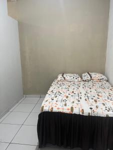 a bedroom with a bed with a comforter on it at Meu cantinho in Santarém