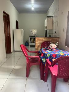 a kitchen with a table and chairs and a refrigerator at Meu cantinho in Santarém