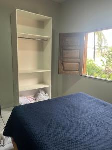 a bedroom with a blue bed and a window at Meu cantinho in Santarém