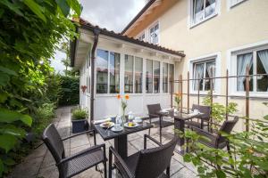 a patio with tables and chairs on a balcony at Hotel Eschenhof in Kirchheim