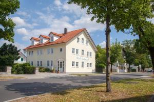 un gran edificio blanco con techo rojo en Hotel Eschenhof en Kirchheim