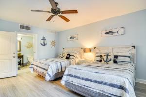 two beds in a bedroom with a ceiling fan at Waterfront Condo with Water Park, Walk to the Beach! in Clearwater Beach +24 photos