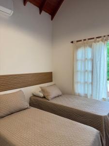 two beds in a room with a window at Merlinda in Merlo