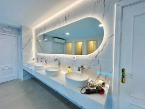 a bathroom with three sinks and a large mirror at UNPLAN Hostel in Madrid