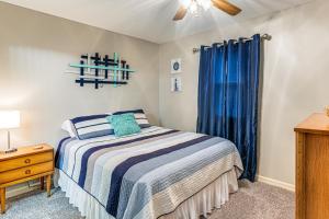 a bedroom with a bed and a blue curtain at Kentucky Lake Retreat Near Marina and Launch! in Faxon