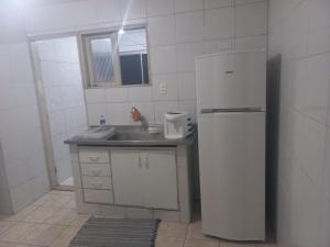 a kitchen with a white refrigerator and a sink at Apartamento para temporada Garanhuns in Garanhuns