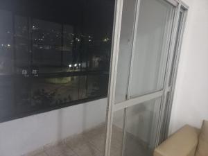 a glass window in a room with a couch at Apartamento para temporada Garanhuns in Garanhuns +3 photos