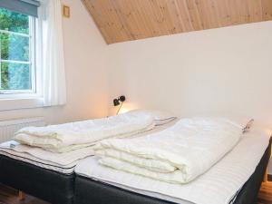 a unmade bed in a room with a window at Luxury Retreat with Pool - By Traum Ferienwohnungen in Ulfborg +52 photos