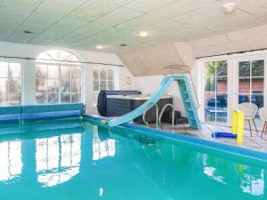a swimming pool with a slide in the water at Luxury Retreat with Pool - By Traum Ferienwohnungen in Ulfborg