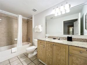 a bathroom with a toilet and a sink and a mirror at Spacious 3 Bed 3 Bath Luxury Condo 5 min from Disney in Orlando +35 photos