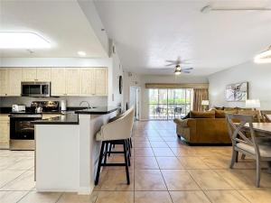 a kitchen and living room with a couch and a table at Spacious 3 Bed 3 Bath Luxury Condo 5 min from Disney in Orlando