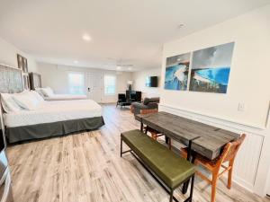 a bedroom with a bed and a table in a room at 304 Queen Suite, 3rd Floor Nest in Surf City