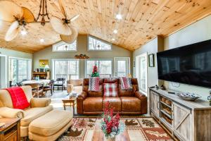 ein Wohnzimmer mit Ledermöbeln und einem großen TV in der Unterkunft Riverfront Newland Home with Pool and Golf Club Access in Newland