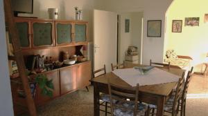 ein Esszimmer mit einem Tisch und ein Zimmer mit einem Sofa in der Unterkunft Polcanto i Castagni appartamento in casa colonica in Borgo San Lorenzo + 13 Fotos