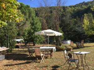 einen Tisch und Stühle mit Sonnenschirm im Hof in der Unterkunft Polcanto i Castagni appartamento in casa colonica in Borgo San Lorenzo