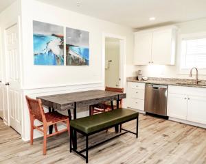 a kitchen with white cabinets and a wooden table and chair at 304 Queen Suite, 3rd Floor Nest in Surf City +32 photos