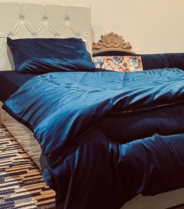 a bed with a blue blanket on top of it at شقه كبيرة in Hail