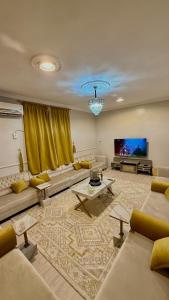 a living room with couches and a flat screen tv at شقه كبيرة in Hail